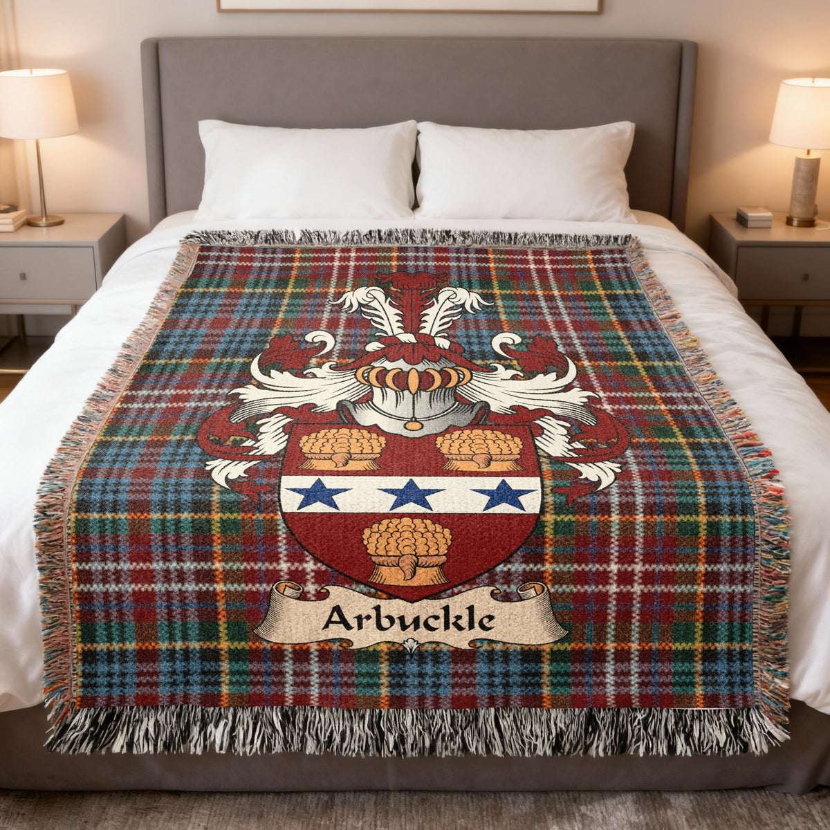 Arbuckle Scottish family crest woven blanket on a Caledonia tartan background, displayed on a bed