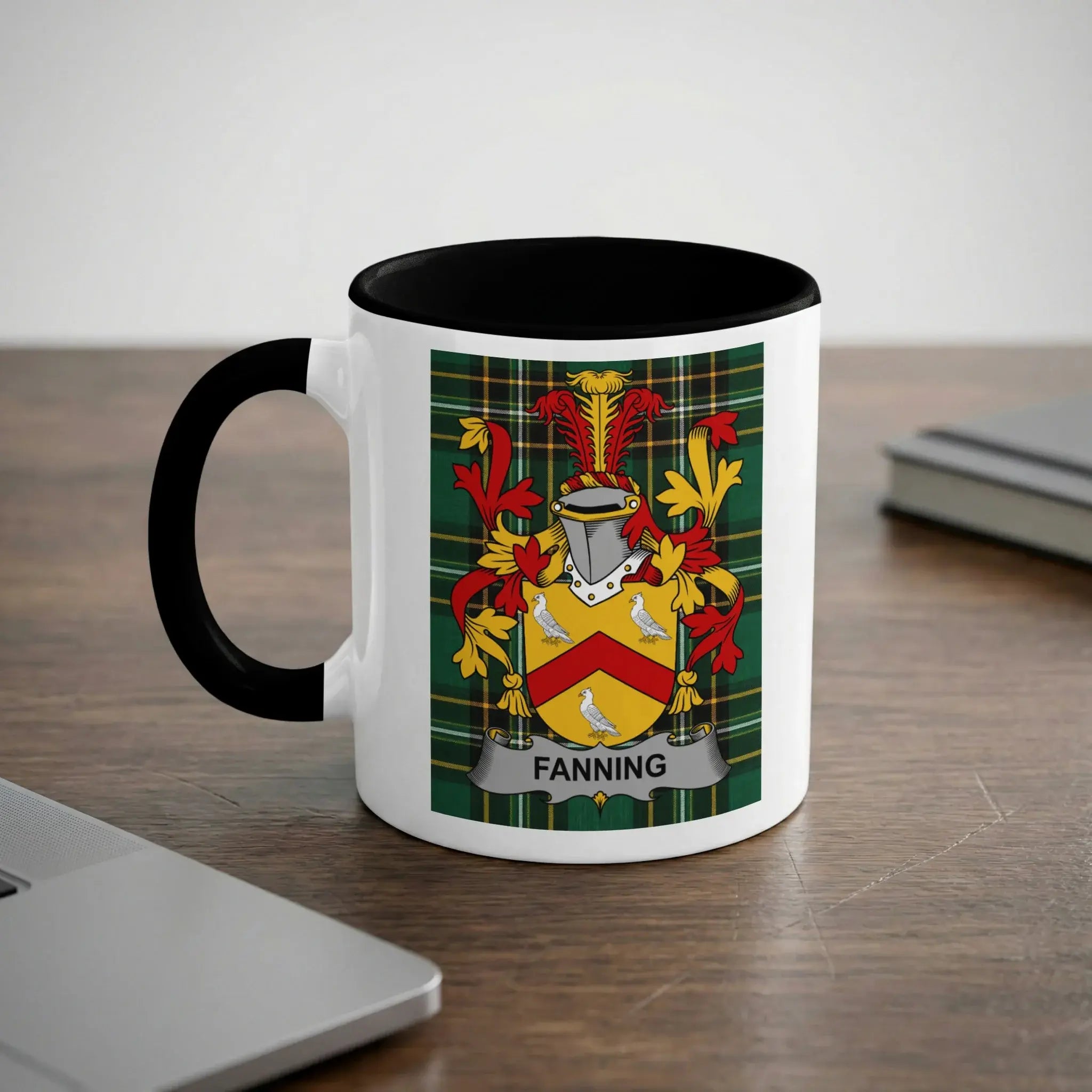 White mug with black rim and handle, displaying the Fanning family crest.
