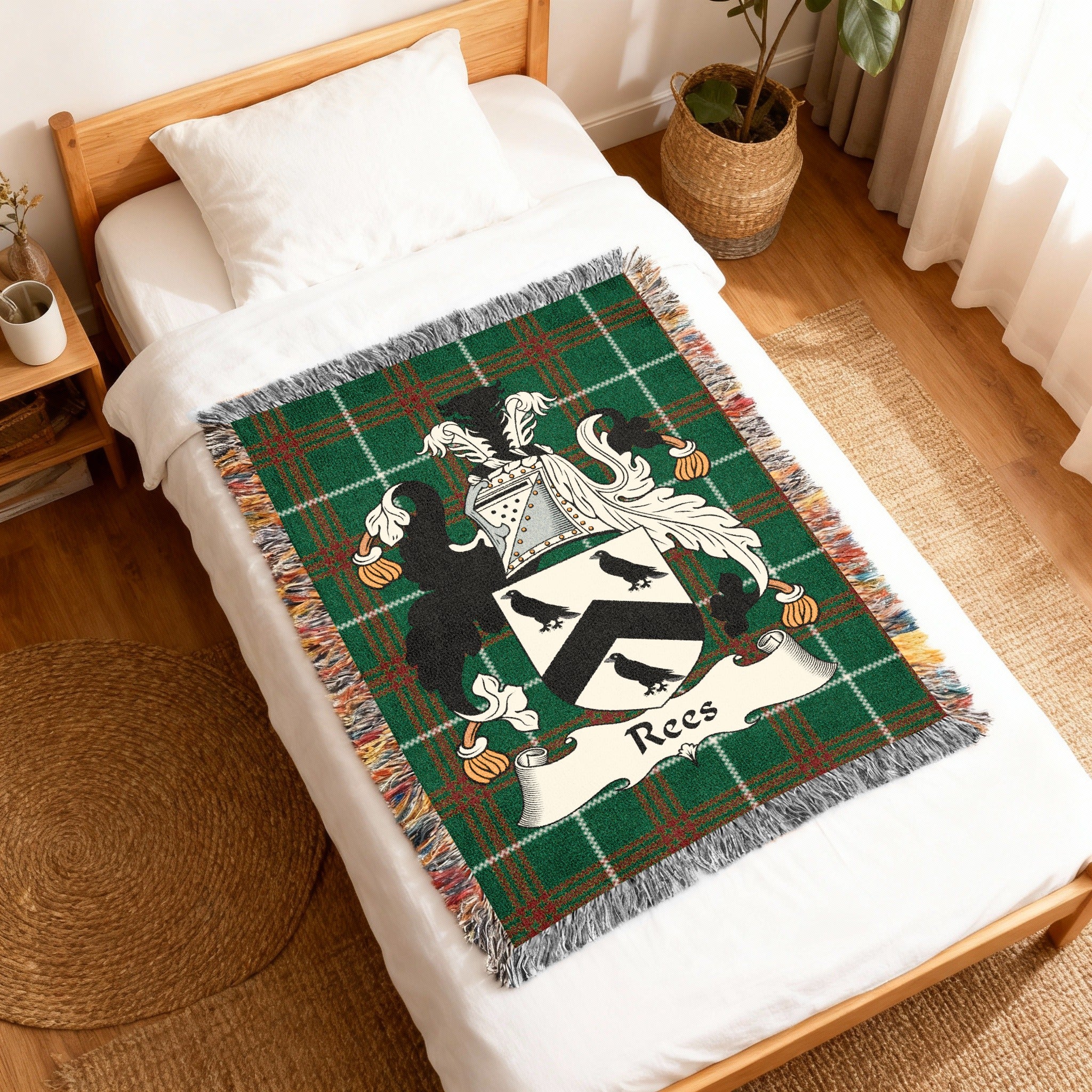 Green tartan blanket with a crest and "Rees" name displayed on a bed.