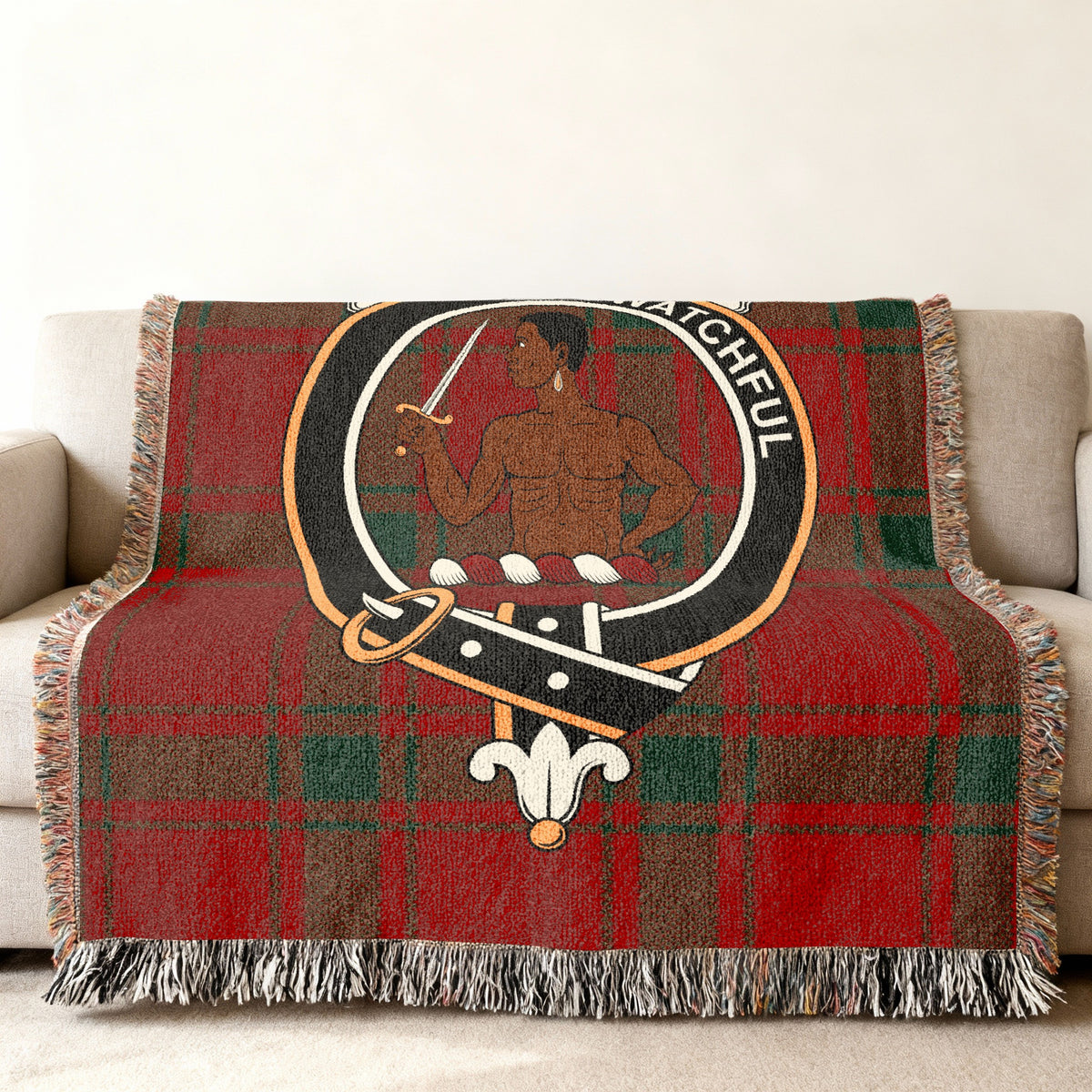 Close view of the Darroch woven blanket draped over a sofa, showing the crest and fringed edges