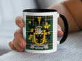 Mug with a black rim and handle featuring the Browne family crest on a tartan background.