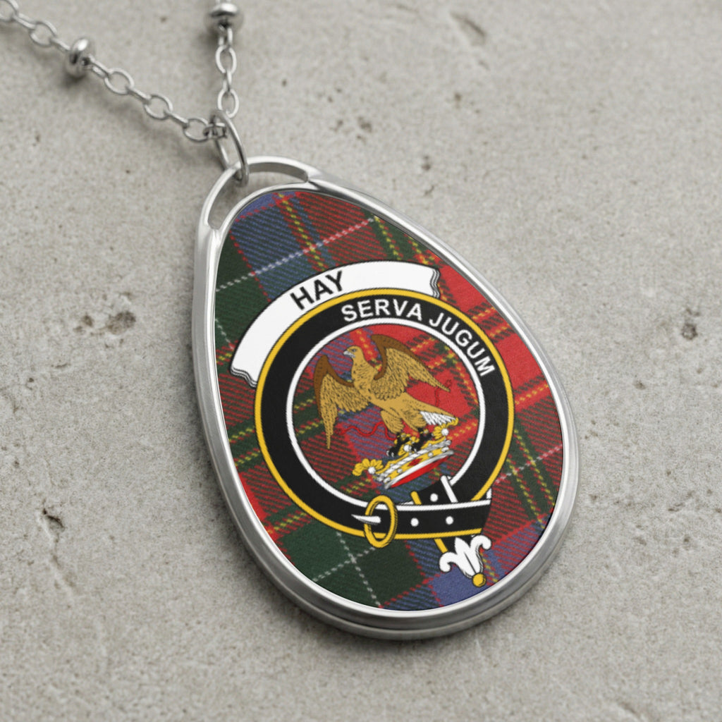 Pendant with tartan pattern, eagle crest, and text "HAY SERVA JUGUM" on chain.