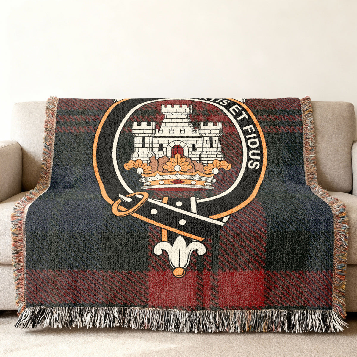 Close view of the MacLachlan woven blanket draped over a sofa, showing the crest and fringed edges