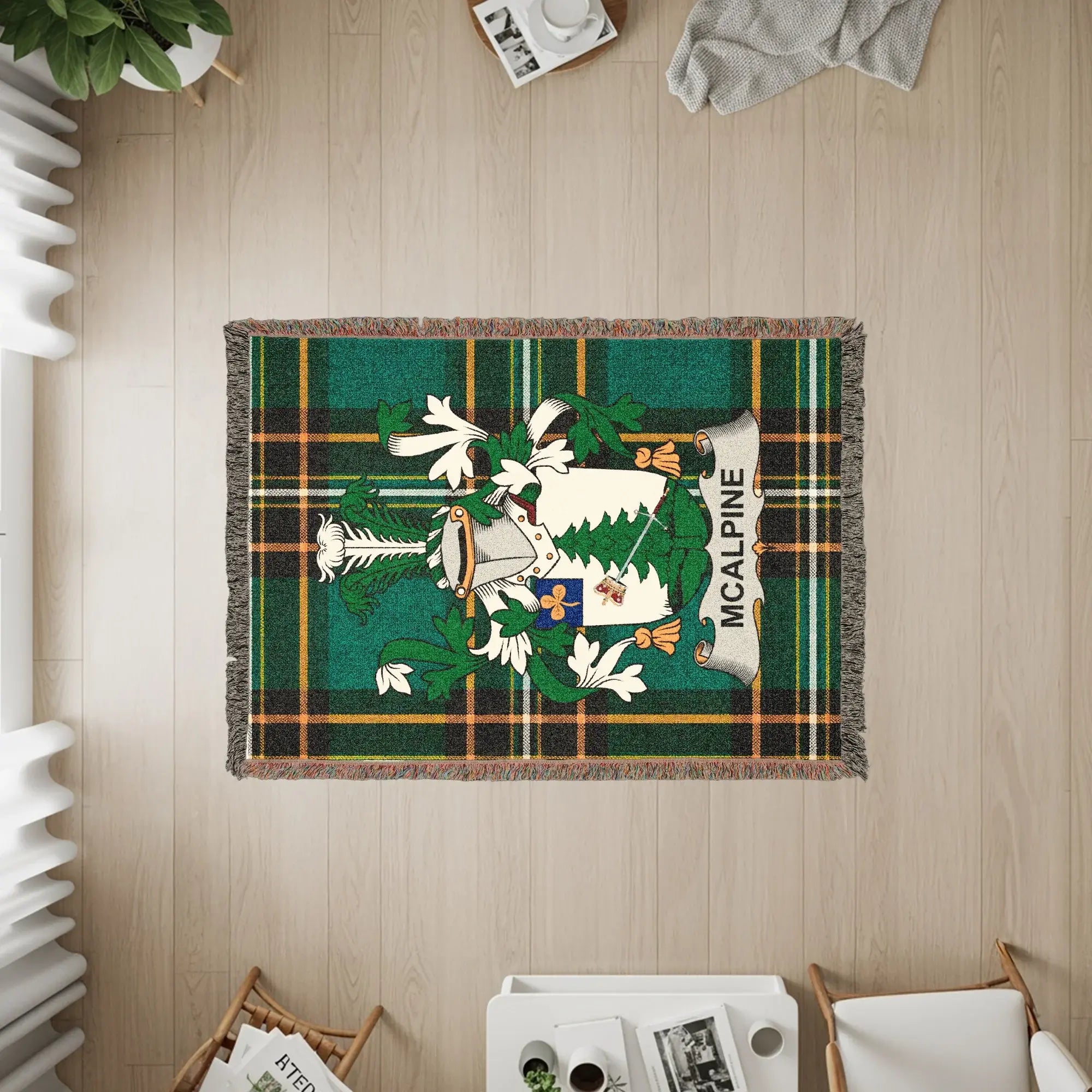 McAlpine tartan blanket with crest and fringed edges on a wooden floor.