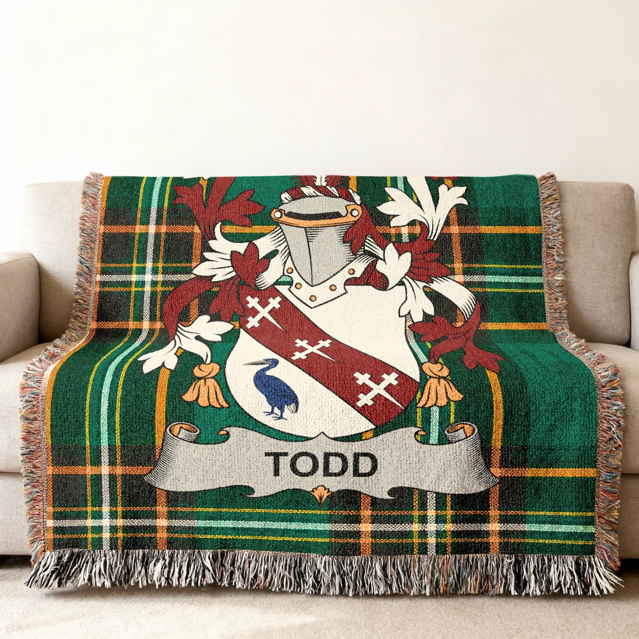 Green plaid blanket with a coat of arms featuring a bird and "TODD".
