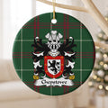 Chepstowe ornament hanging from a pale wooden branch; a black upright lion on white within a red border decorated with small gold crosses on Welsh national tartan.