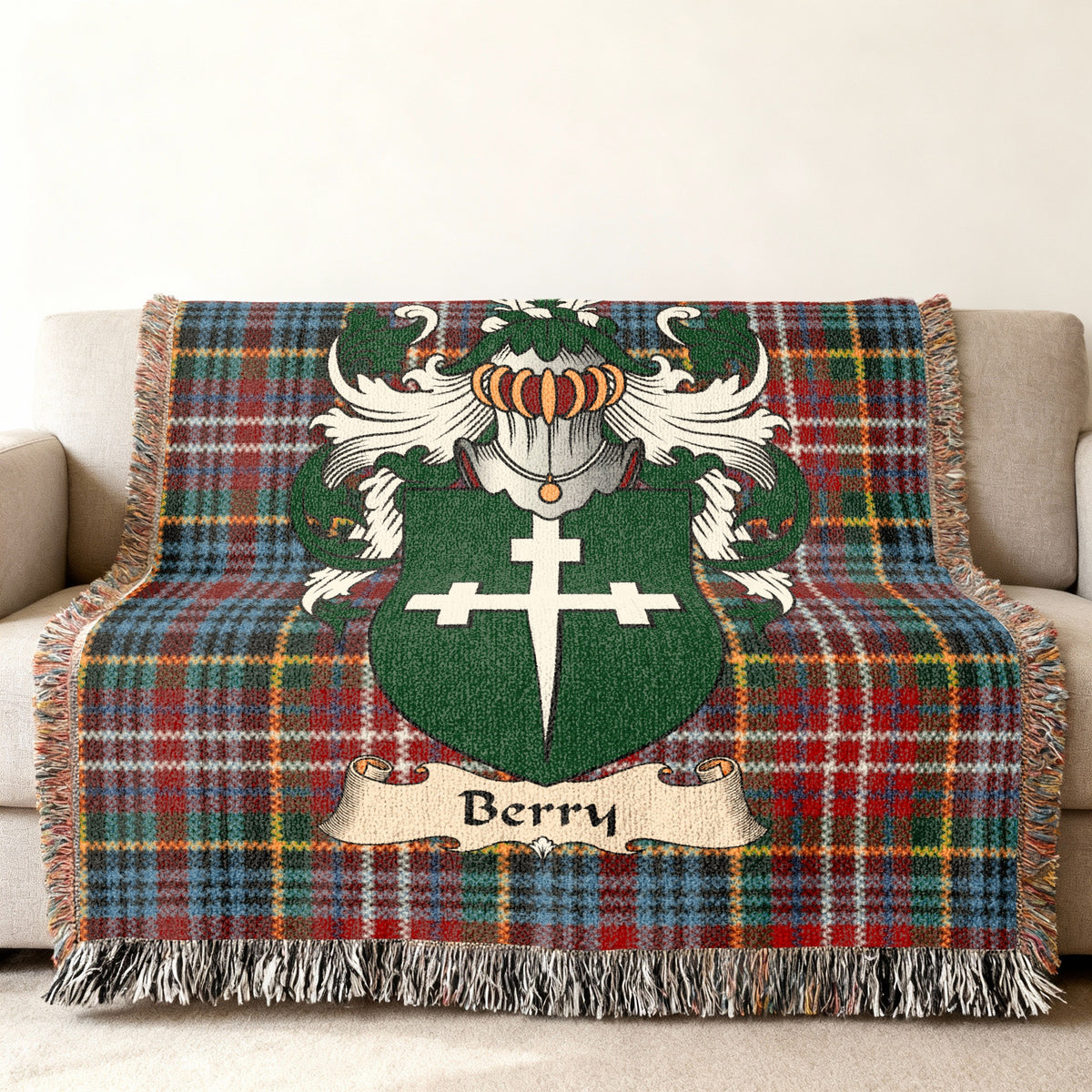 Berry Scottish family shield woven blanket with Caledonia tartan background on a sofa