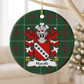 Harold ornament hanging from a pale wooden branch; five black stars on a white diagonal band across a red shield on Welsh national tartan.