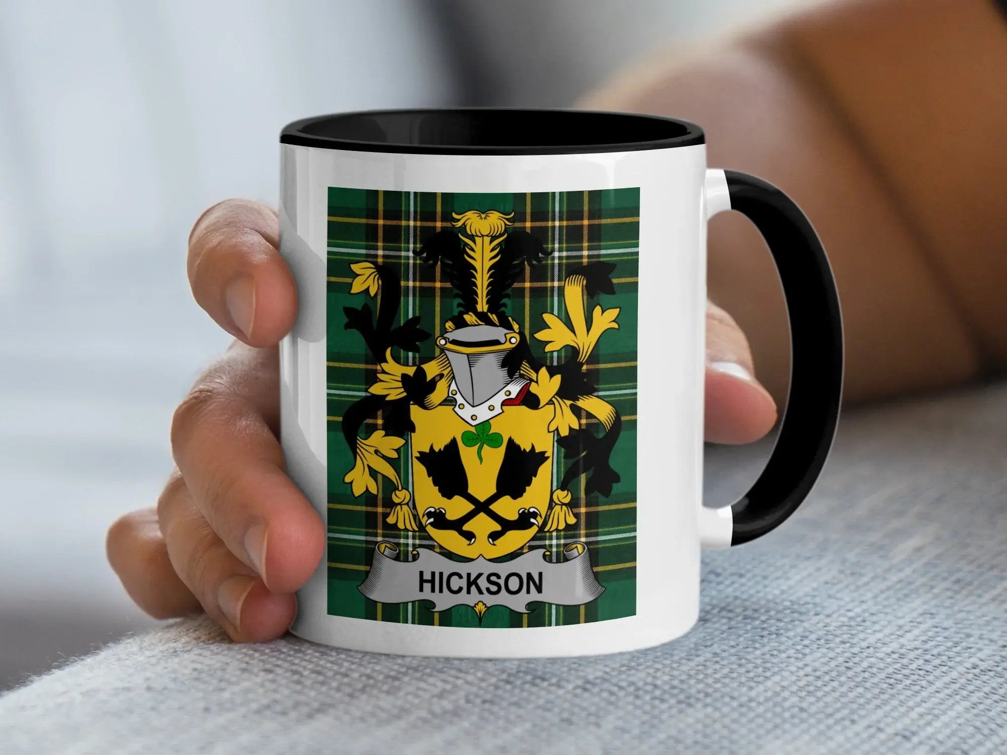 White mug with black rim, featuring Hickson family crest on plaid background.