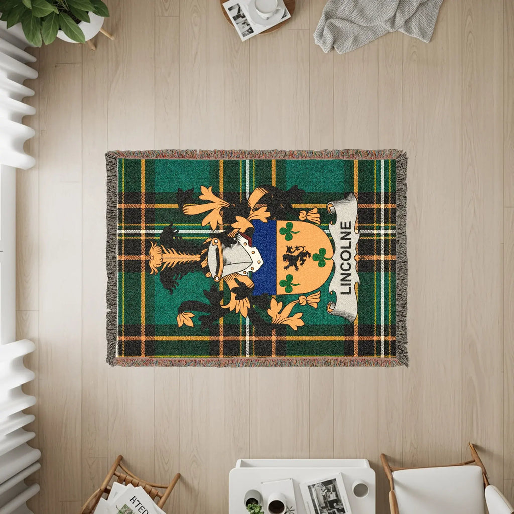 Woven blanket with the Lincoln coat of arms on a green and black tartan background.