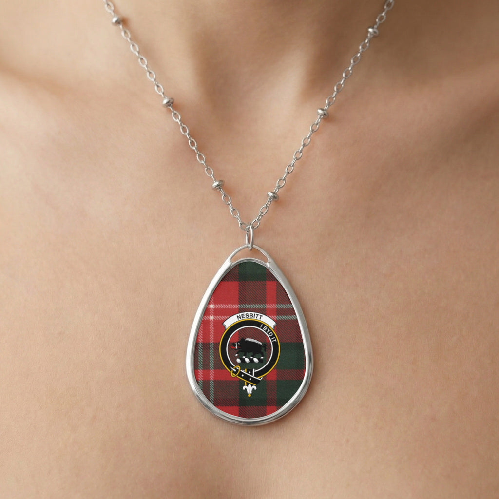 Oval pendant with red and green plaid and Nesbitt crest on a silver chain.