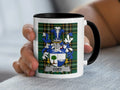 White mug with black handle featuring a blue and green plaid pattern and a family crest.