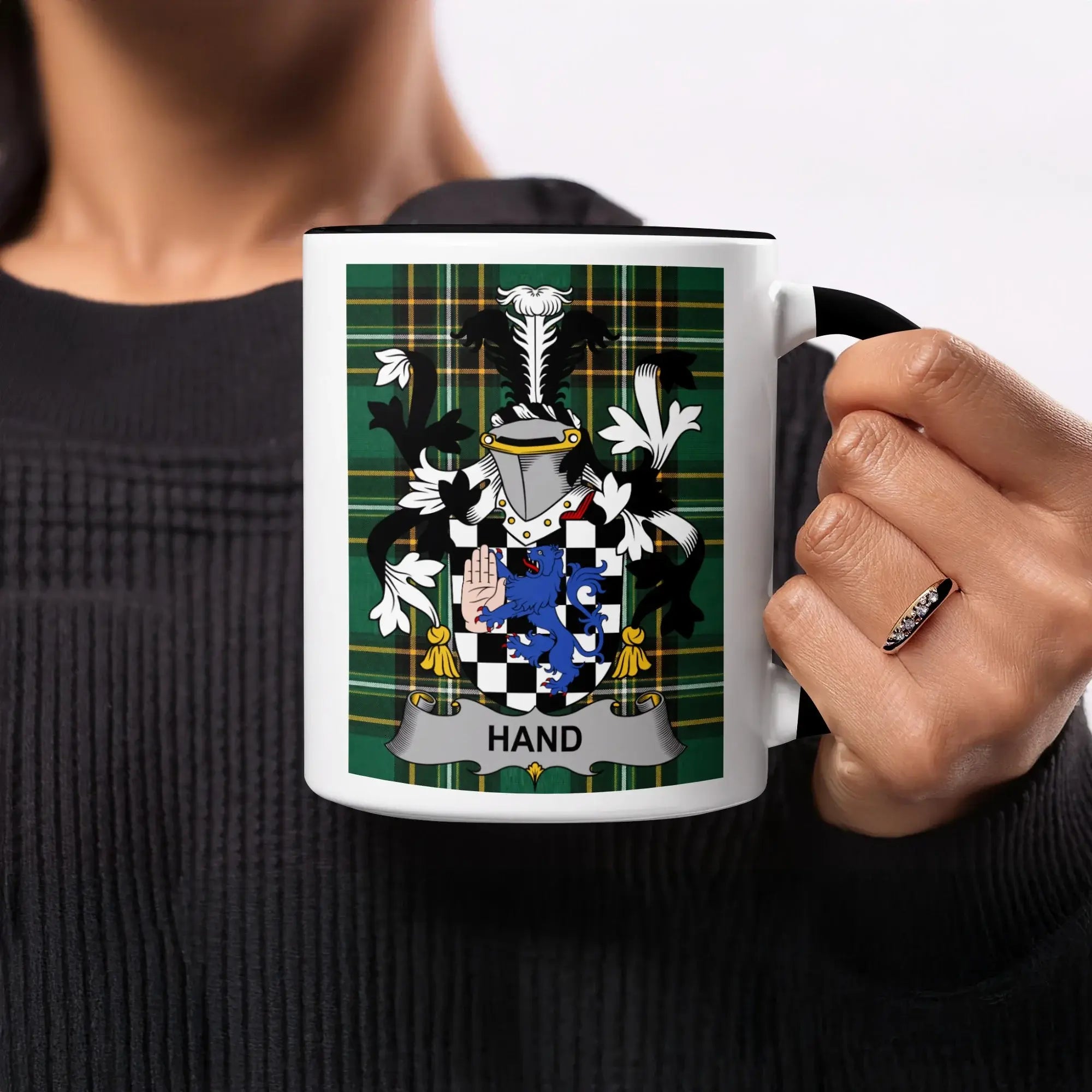 Mug with Hand family crest on tartan background.