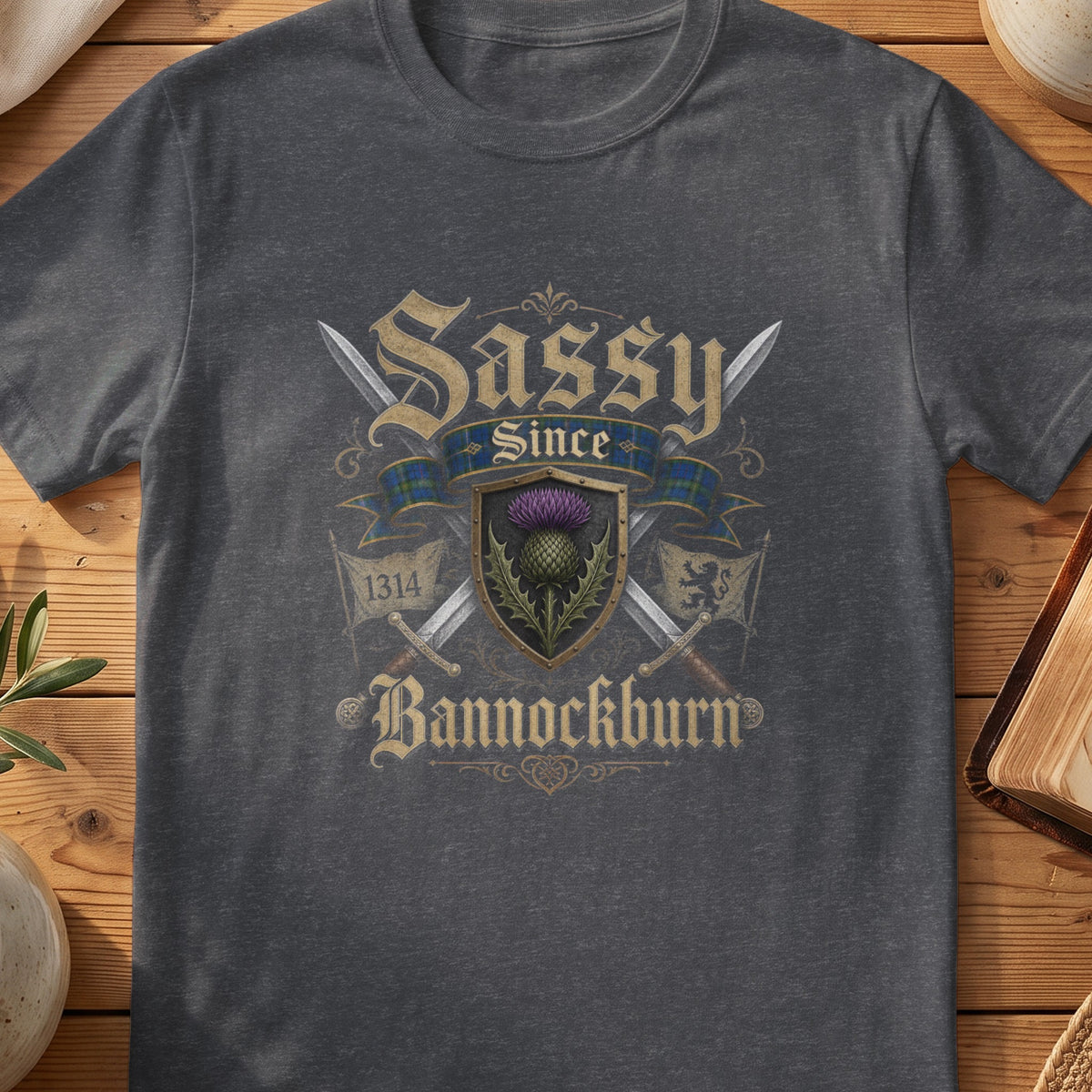 Dark grey Gildan 64000 unisex T-shirt flatlay with Sassy Since Bannockburn 1314 Scottish graphic design