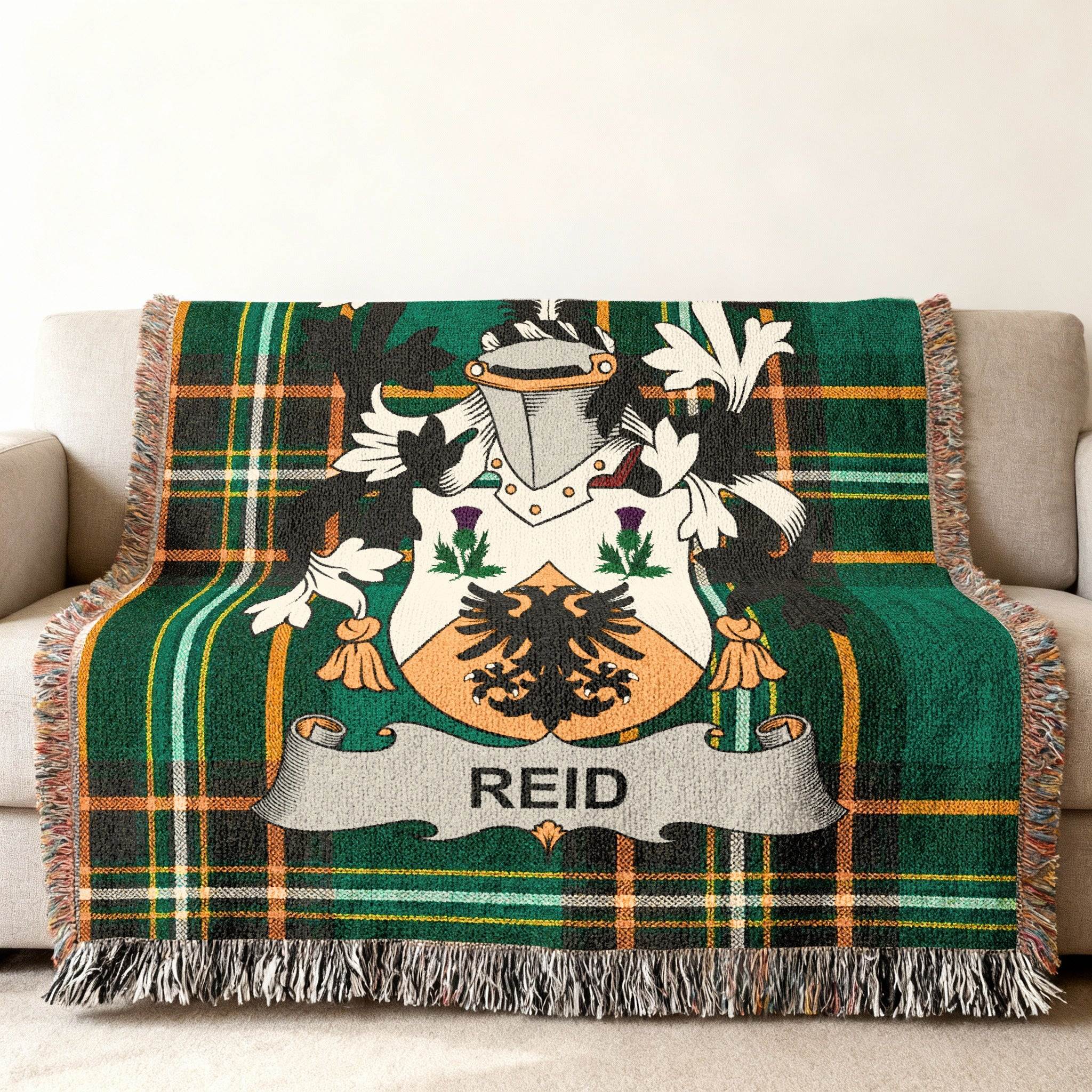 Green plaid throw blanket with a family crest featuring a shield and the name "REID".