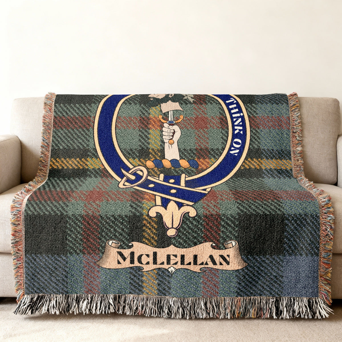 Close view of the McLellan woven blanket draped over a sofa, showing the crest and fringed edges