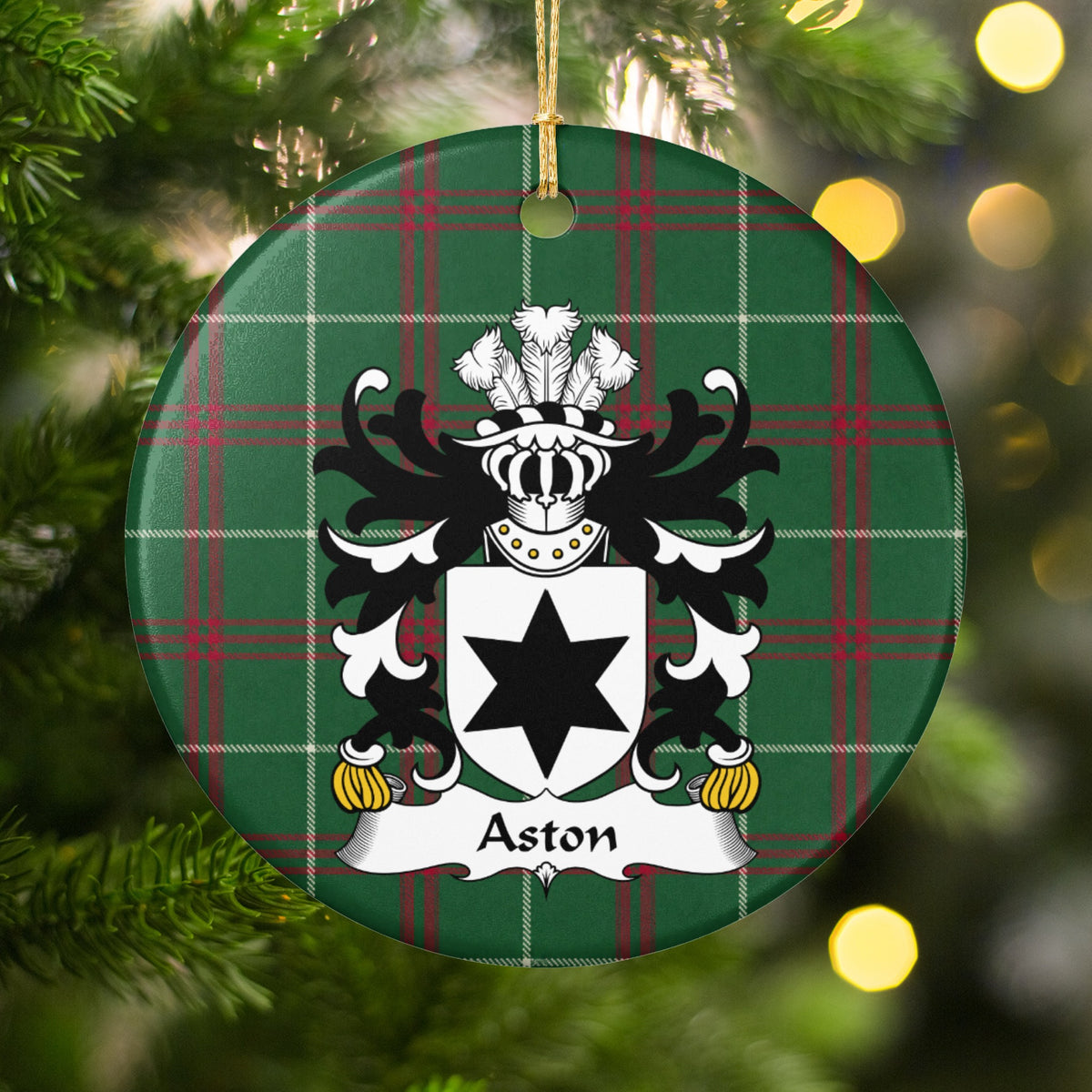 Aston ornament among Christmas tree branches and warm lights; a single black six-pointed star on a white shield on Welsh national tartan.
