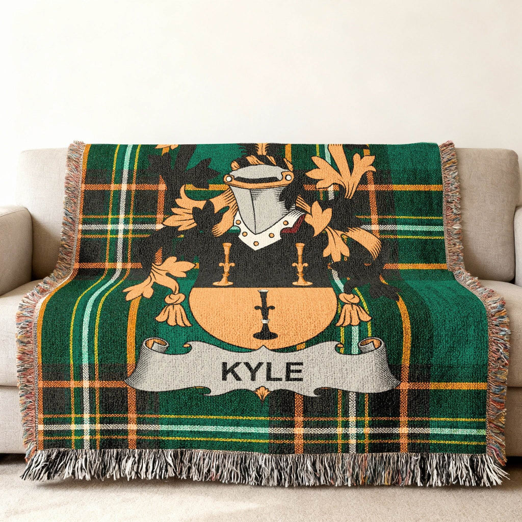 Woven tartan throw blanket with Kyle family crest in center.