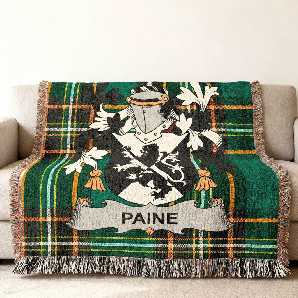 Green plaid throw blanket featuring the Paine family crest with a shield and helmet.