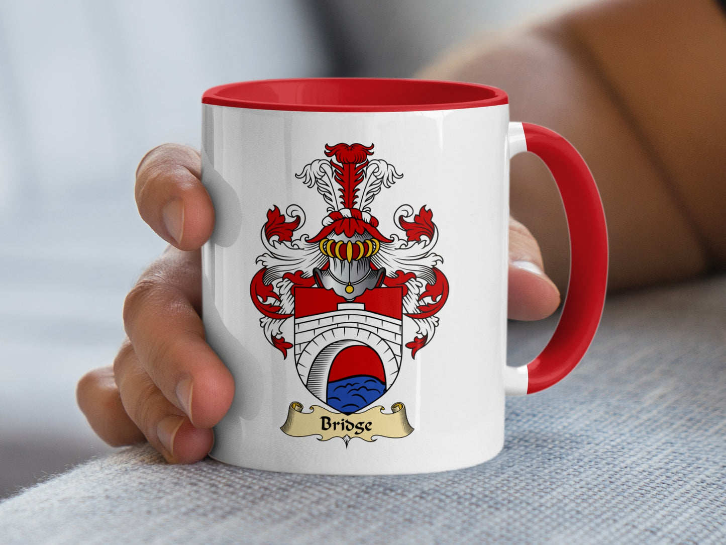 White mug with red handle, featuring a coat of arms and the name "Bridge".