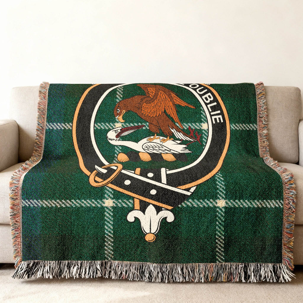 Graham tartan woven blanket on bed — 80x60 size, blue green and black plaid with crest