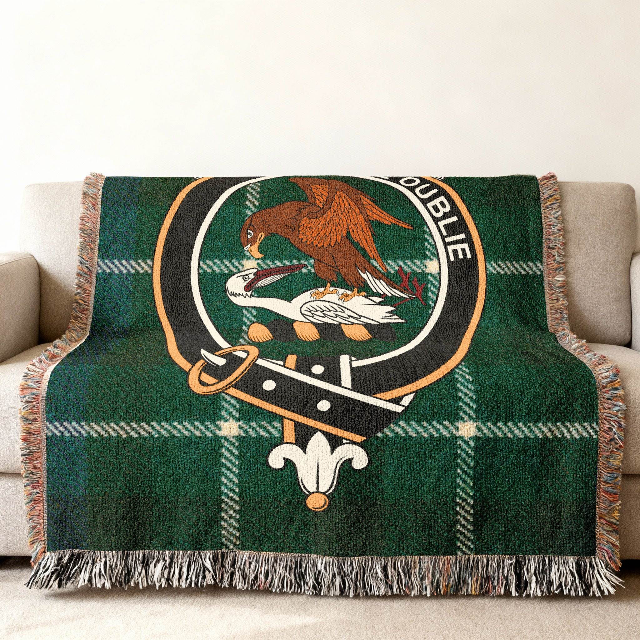 Graham tartan woven blanket on bed — 80x60 size, blue green and black plaid with crest