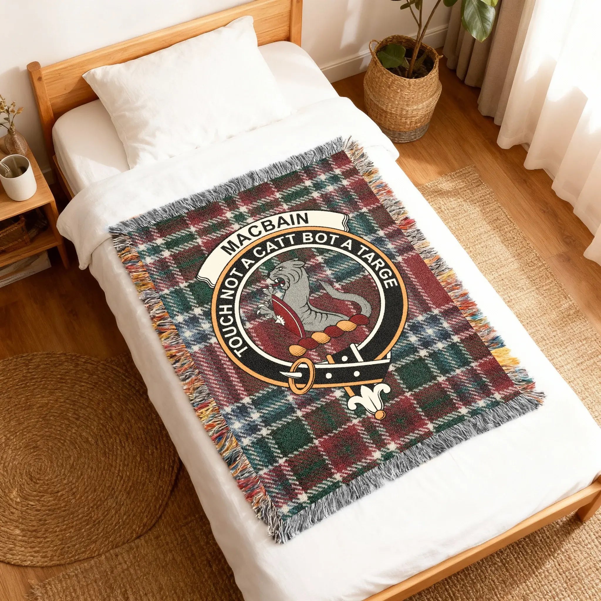 Clan MacBain tartan woven blanket — folded showing fringe detail and wildcat crest on tartan