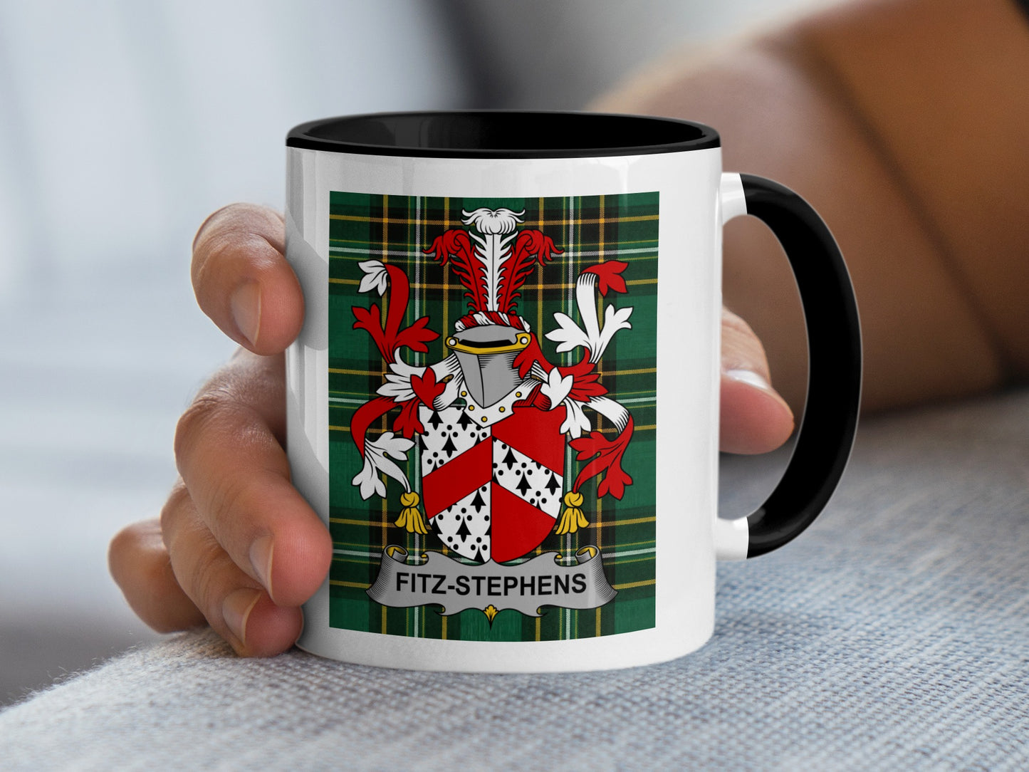White mug with black rim featuring Fitz-Stephens family crest on plaid background.