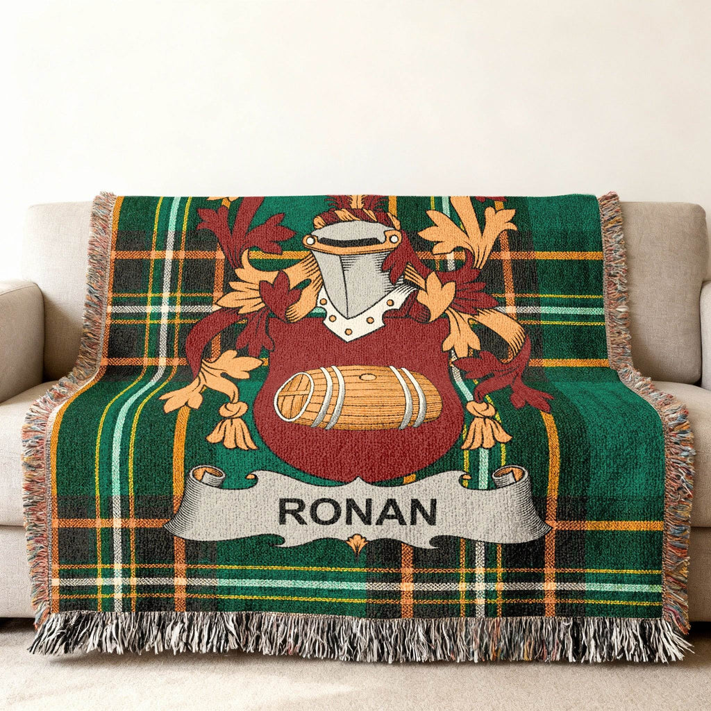 Green tartan blanket with Ronan family crest on sofa.