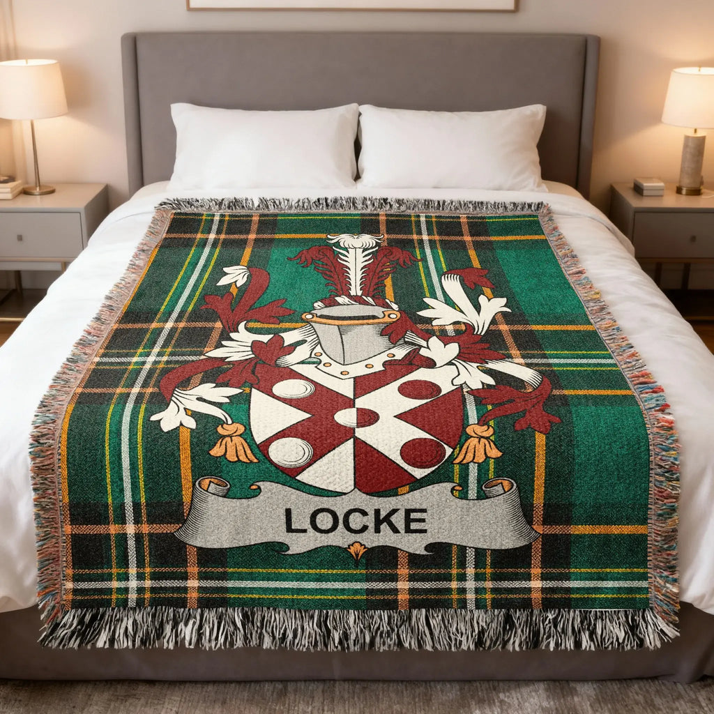 Green plaid blanket with Locke family crest and banner displayed on a bed.