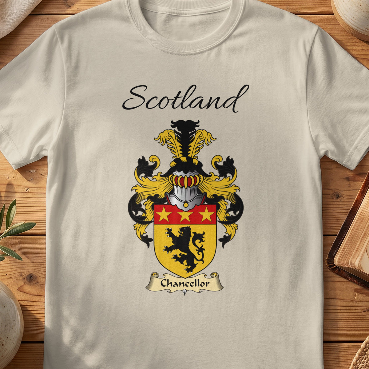 Sand Chancellor Scottish family shield T-shirt featuring a black lion beneath a red band with gold stars