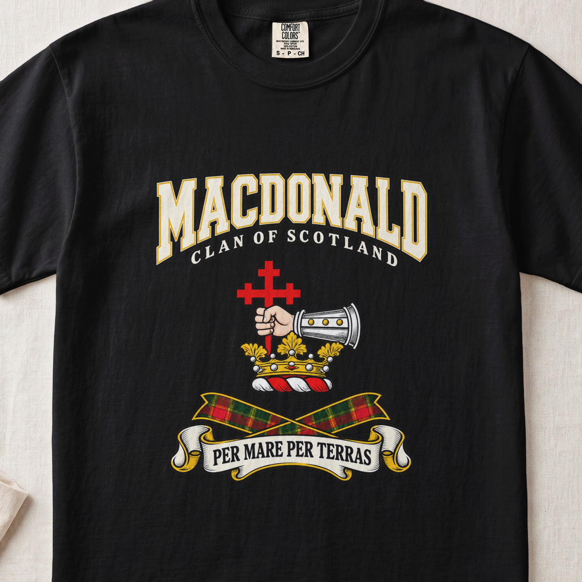 MacDonald graphic T-shirt in Black, front flat lay showing varsity lettering and armoured forearm with hand holding red cross.