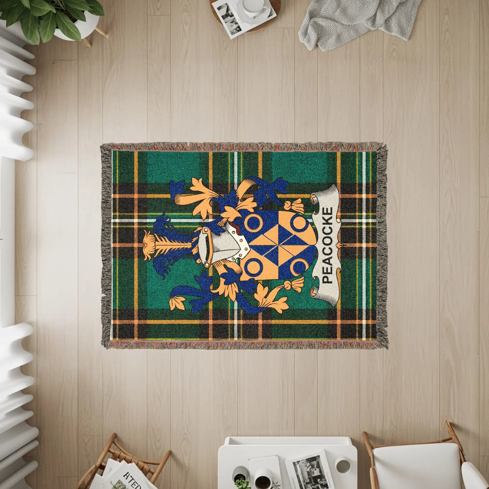 Green plaid woven blanket with PEACOCK crest and gold accents.
