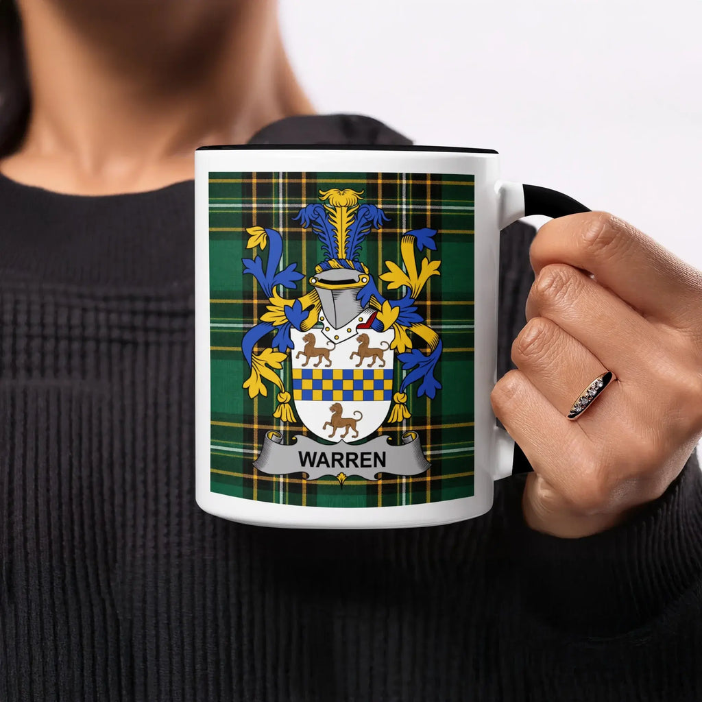 Warren coat of arms on a tartan plaid mug held by a person.