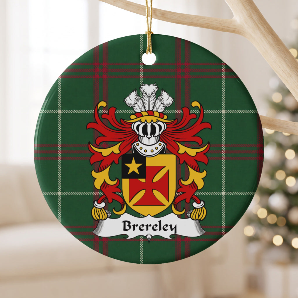 Brereley ornament hanging from a pale wooden branch; a red flared cross on gold with a gold star in a black corner panel on Welsh national tartan.