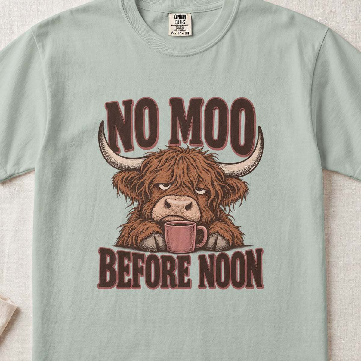 No Moo Before Noon Highland cow design on a Bay Comfort Colors 1717 T-shirt, flat lay