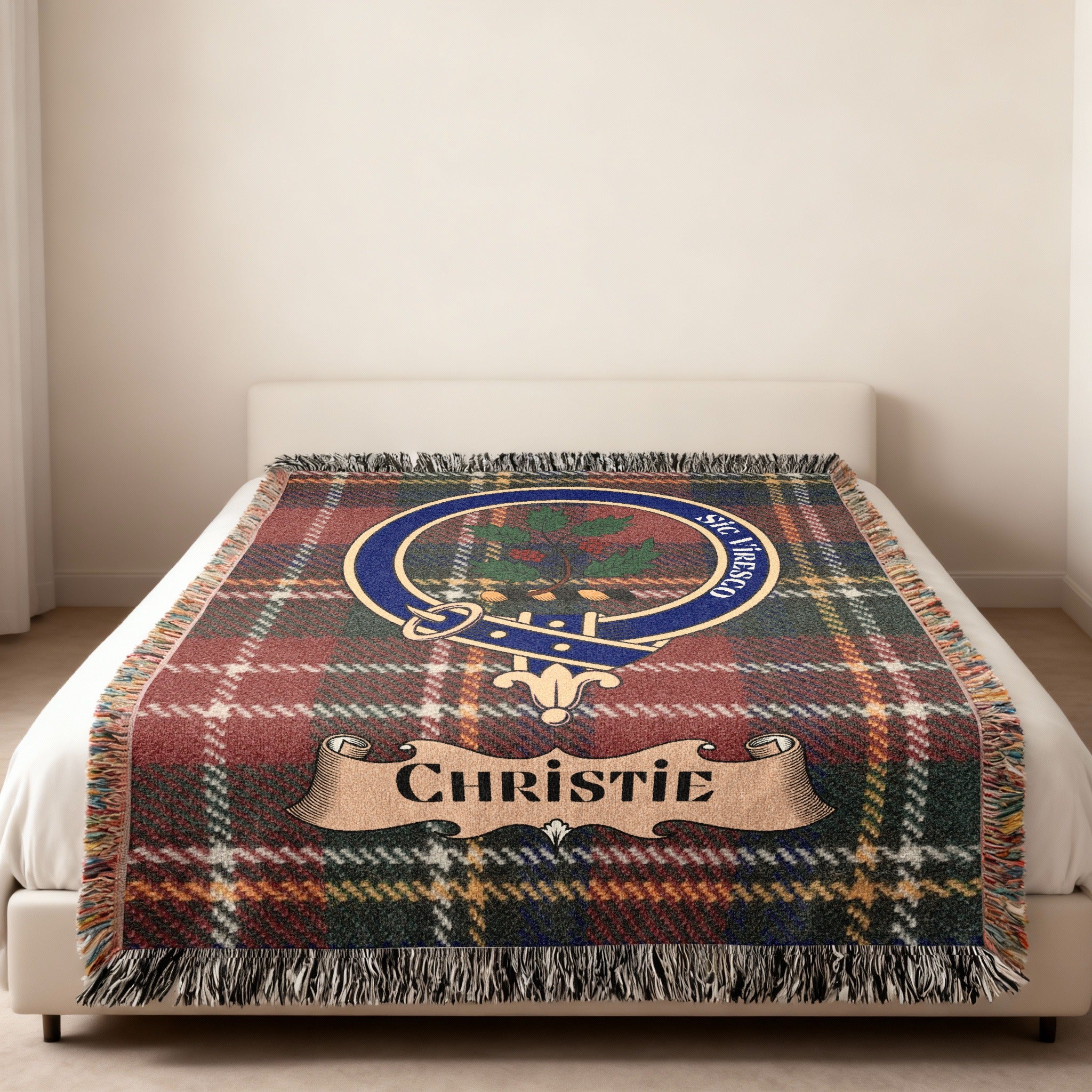 Christie clan tartan woven blanket with crest displayed on a bed