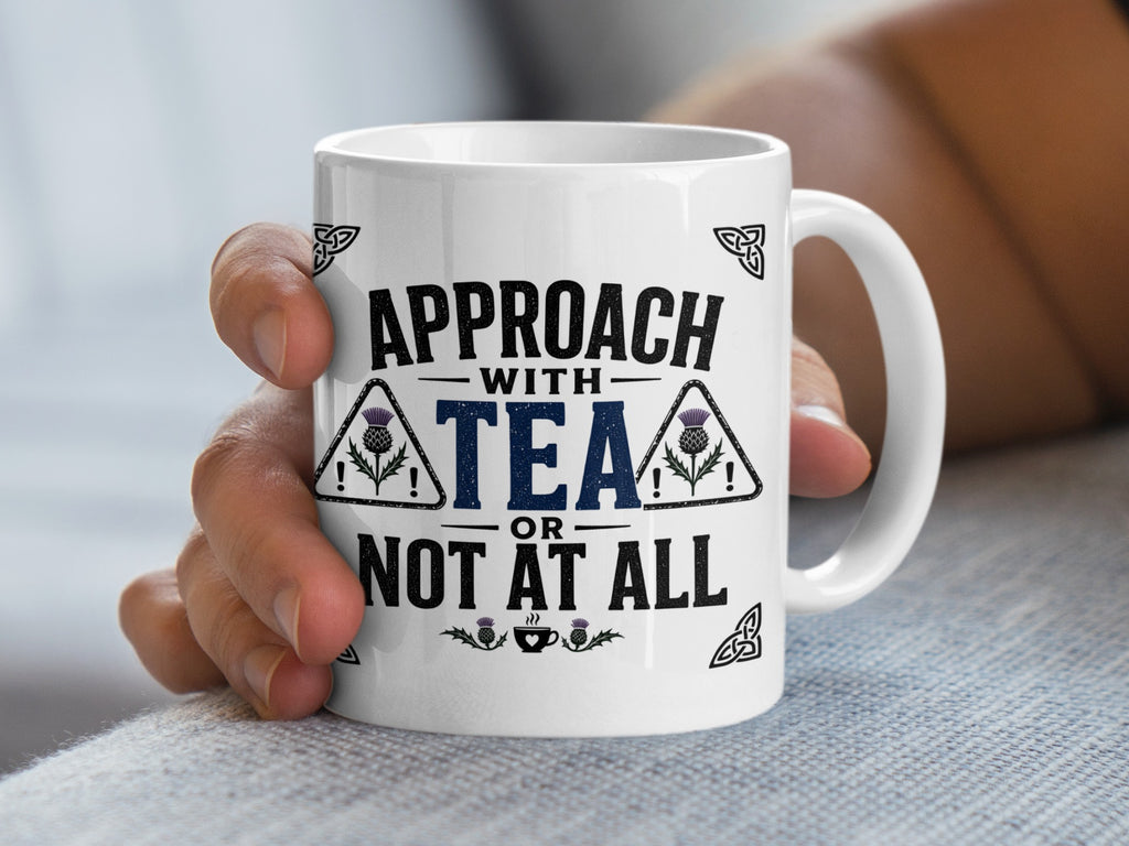 Mug with "Approach with tea or not at all" text and thistle graphic.