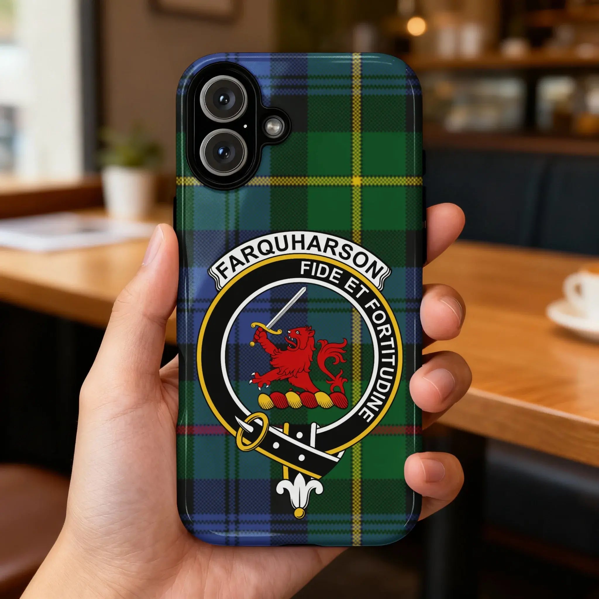 Clan Farquharson tartan case on phone — slim glossy finish, lion crest detail visible, angled view