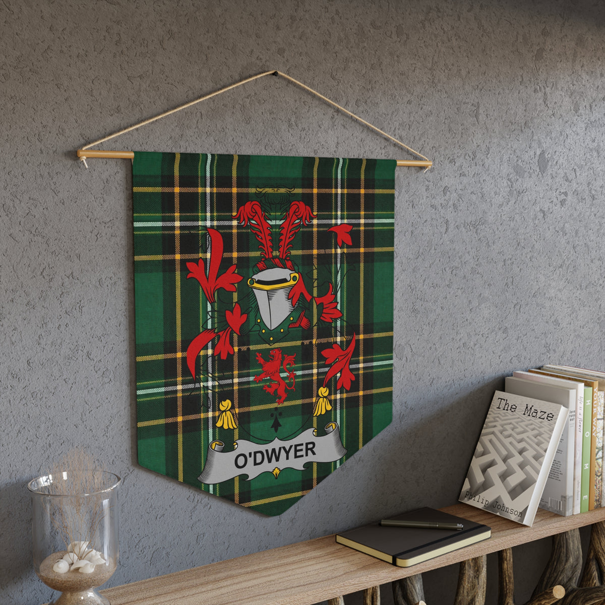 O'Dwyer tartan pennant with crest and a book titled "The Maze" on a shelf.