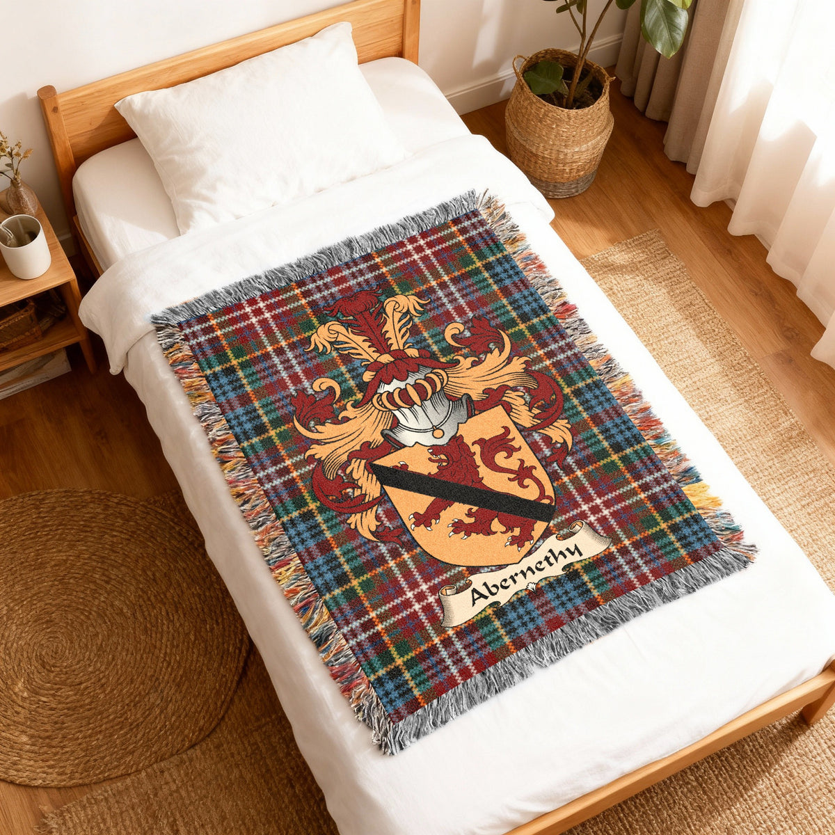 Abernethy Scottish family shield woven blanket with Caledonia tartan background, displayed on a bed