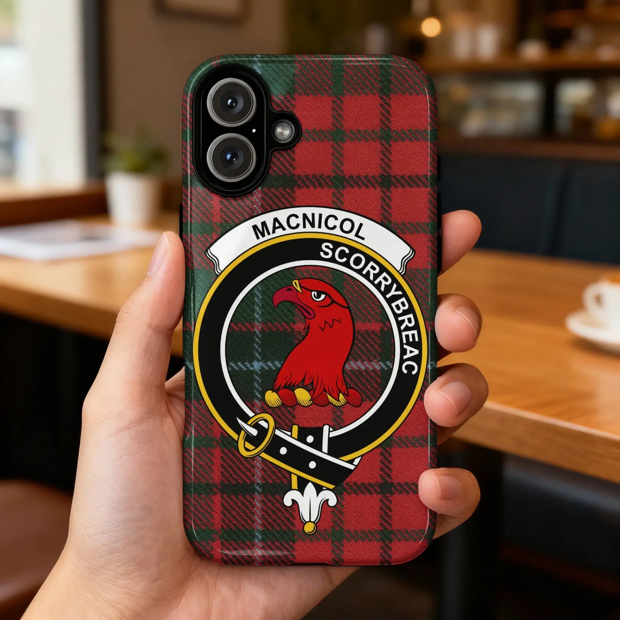 Clan MacNicol Scorrybreac tartan case on iPhone — full-colour crest and plaid wrap, glossy surface
