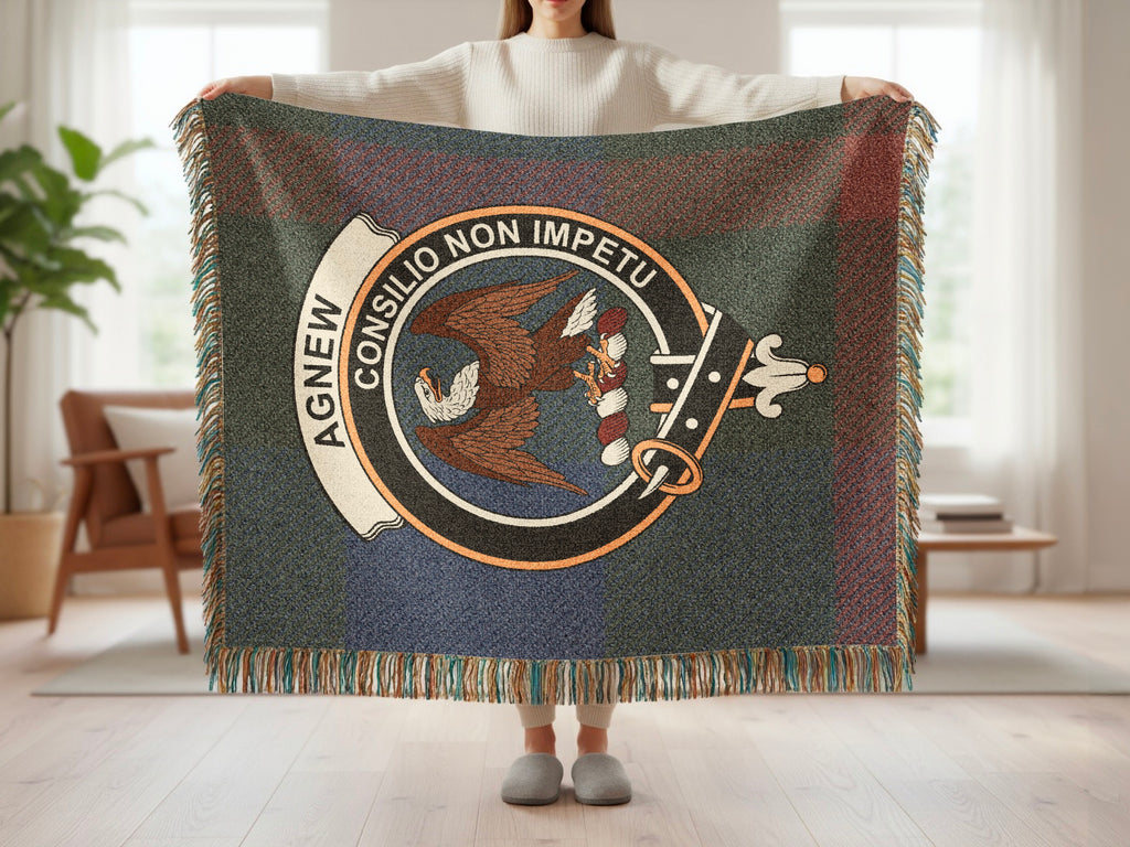 Person holding the Agnew woven blanket to show the full design, tartan background and fringe