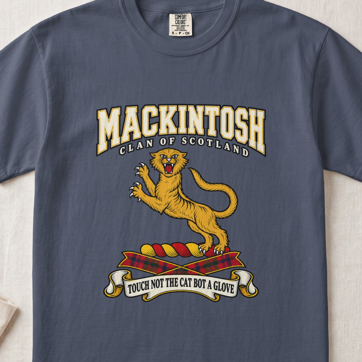 MacKintosh graphic T-shirt in Midnight blue, front flat lay showing varsity lettering and gold leaping wildcat with raised claws and open mouth.