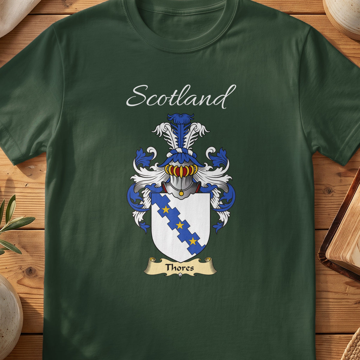Forest Green Thores Scottish T-shirt laid flat with coat of arms artwork and “Scotland” text.
