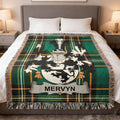 Mervyn tartan blanket with coat of arms draped on a bed.