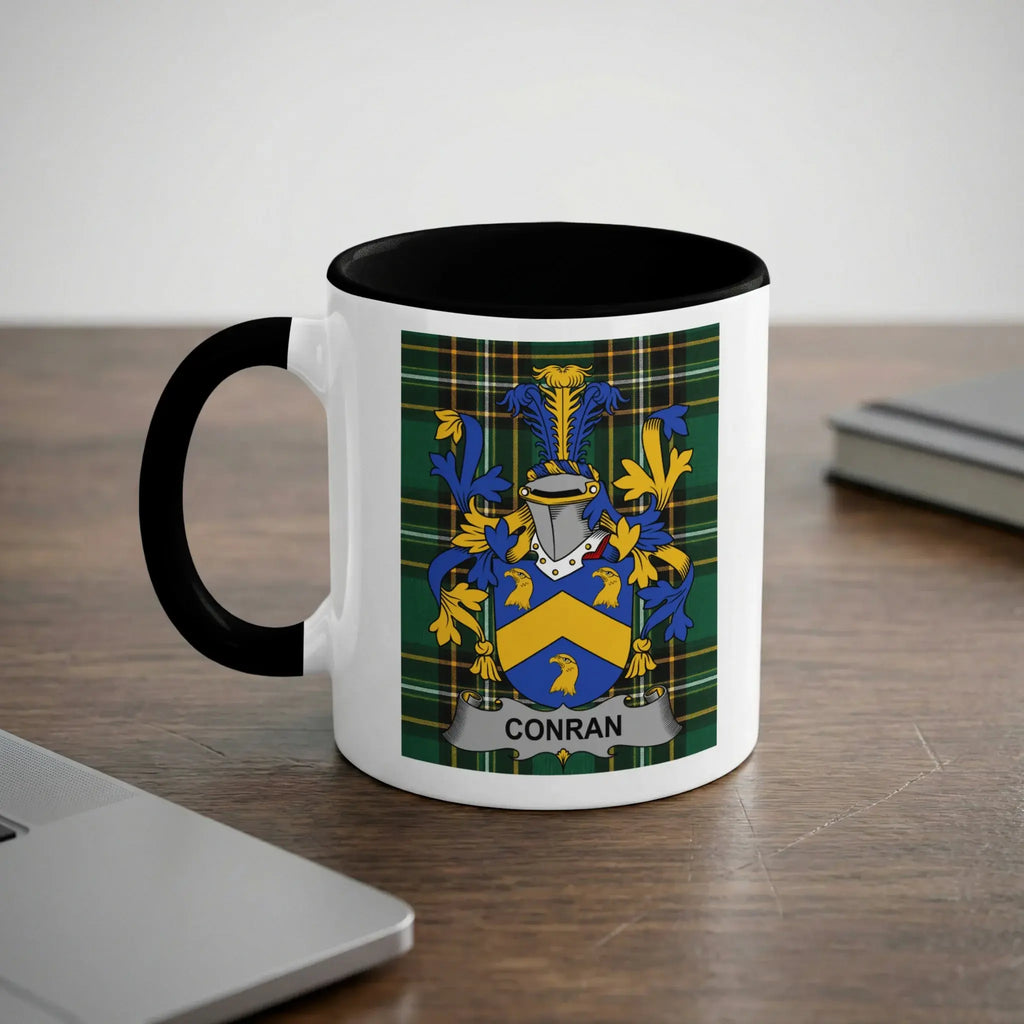 White mug with black rim and handle featuring the Conran family crest.