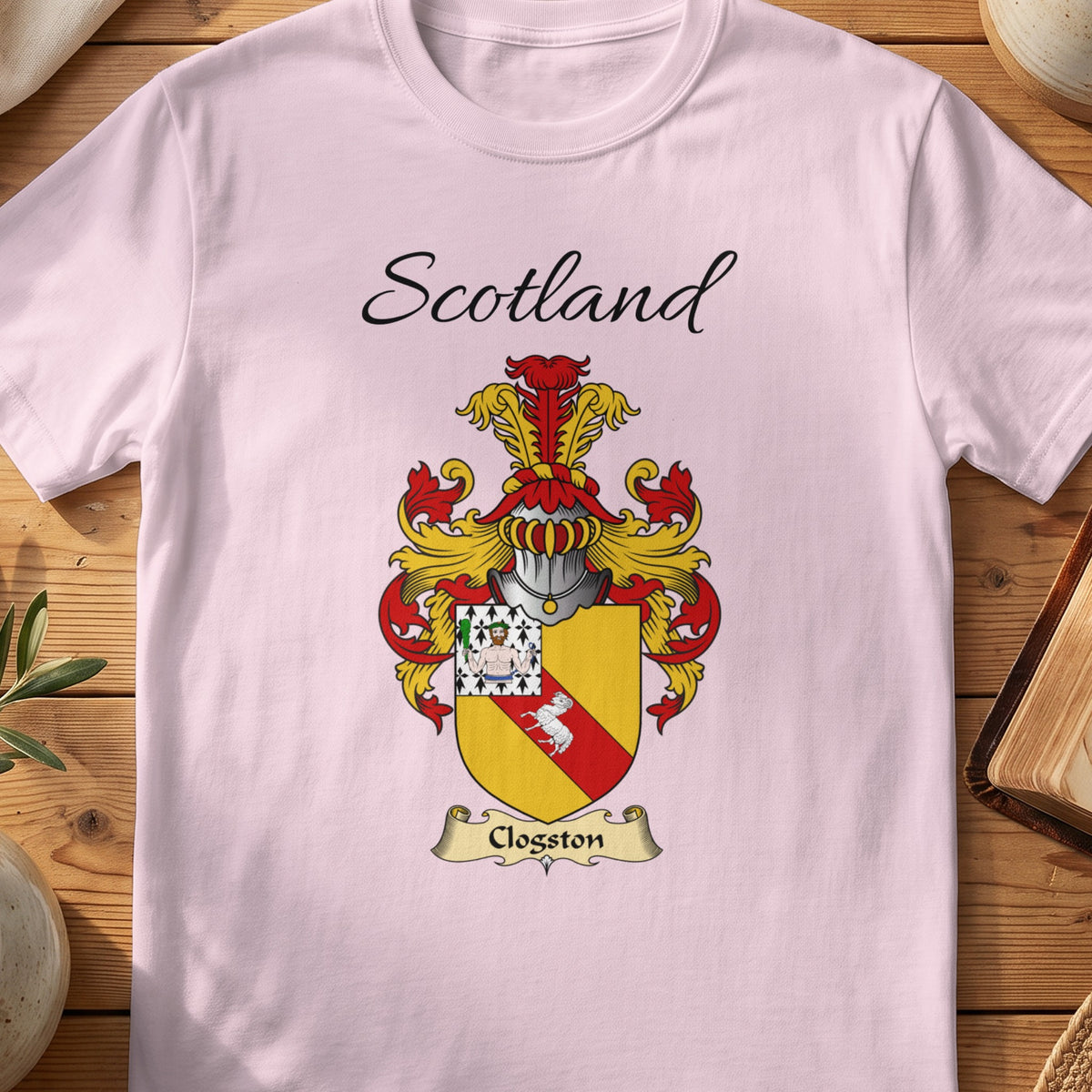 Light Pink Clogston Scottish family shield T-shirt featuring a red diagonal band on gold with a patterned corner