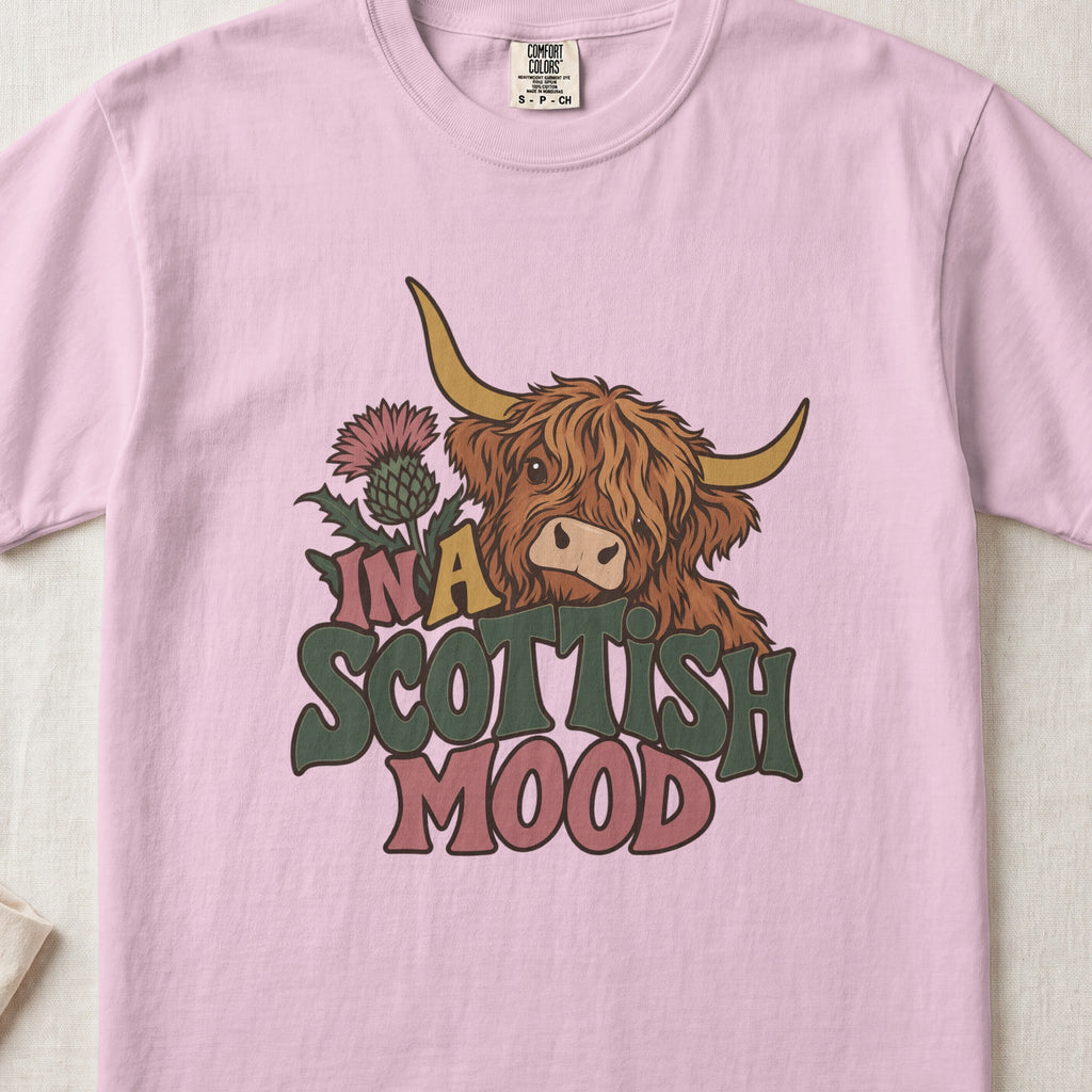 In a Scottish Mood Highland cow design on a Blossom Comfort Colors 1717 T-shirt, flat lay