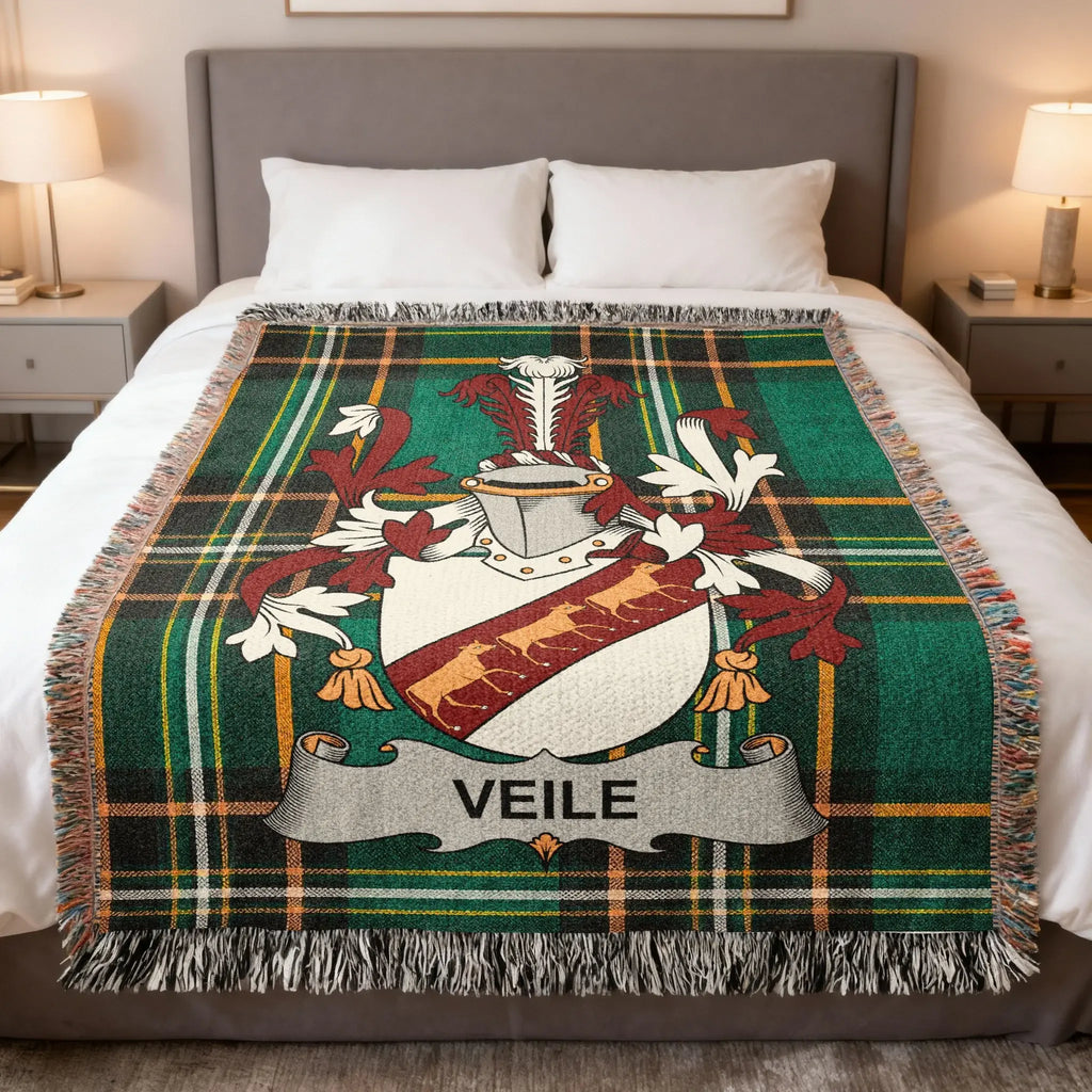 Veile family crest on a green plaid throw blanket on a bed.